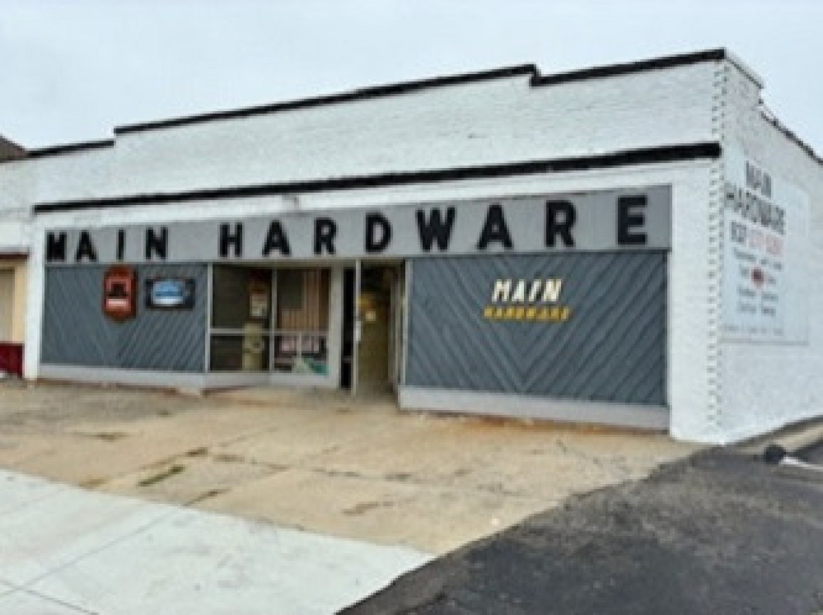 Logo featuring "Main Hardware" in bold script, with "EST. 1987" above. A saw and hammer illustration adds a practical, vintage touch.
